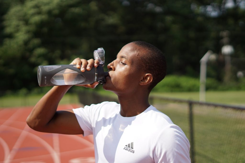 a man drinking water from a tumbler